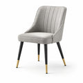 Chaise en tissu polyester gris avec pieds en métal noir et embouts dorés